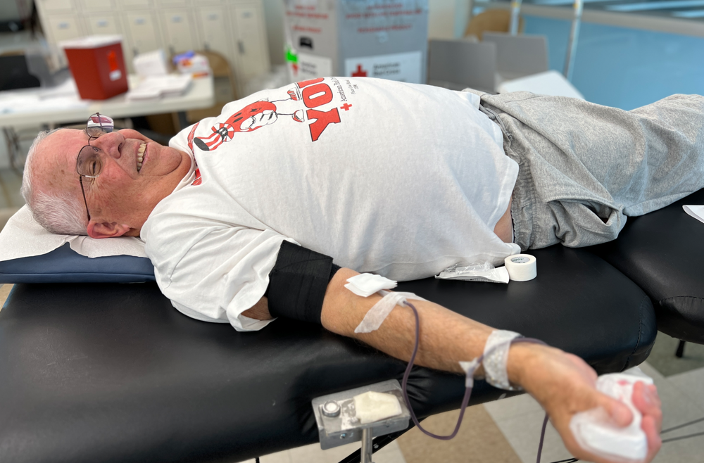 Marc A. Satalof lays on a Red Cross cot, giving blood